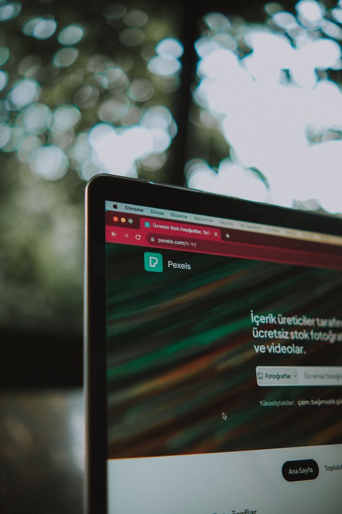 About Close-up of a laptop screen with the Pexels website open, showcasing a vibrant bokeh background.