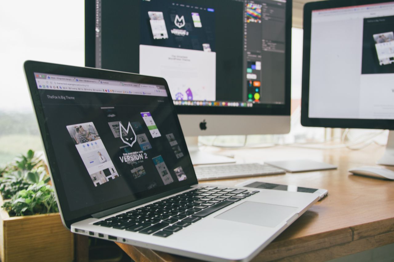 Services A stylish workspace featuring a laptop and monitors displaying design software.