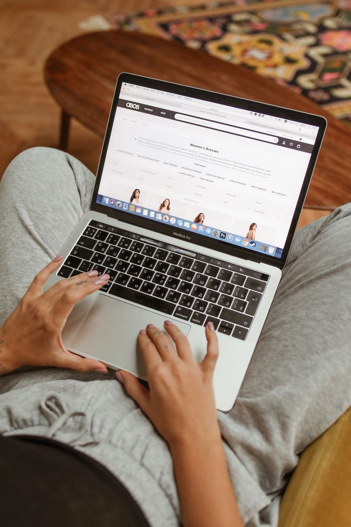 The Art of Drawing Readers In: Your attractive post title goes here Person browsing an online shopping website on a laptop while relaxing indoors.